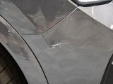 a close up of a car ' s front bumper with scratches on it