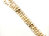 a close up of a bracelet with pearls on a white background