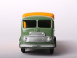 a green and orange toy truck on a white surface