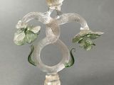 a glass candle holder with a snake and flowers on it