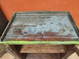 une table en bois sur laquelle est posé un plateau en métal