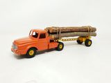 un camion jouet avec une bûche à l'arrière