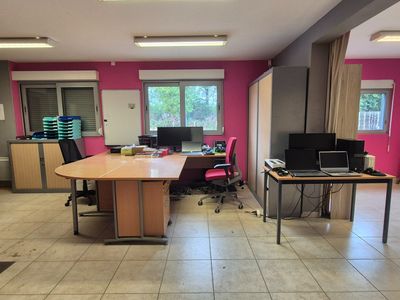 une pièce avec une table, des chaises et un ordinateur portable posé dessus