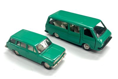 deux petites voitures vertes posées l'une à côté de l'autre sur une surface blanche