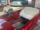 a red car with a white seat in the back of it