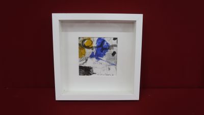 an image of a picture in a white frame on a red surface