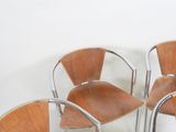 three wooden chairs sitting next to each other against a white wall