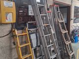 de nombreuses échelles appuyées contre un mur dans un entrepôt
