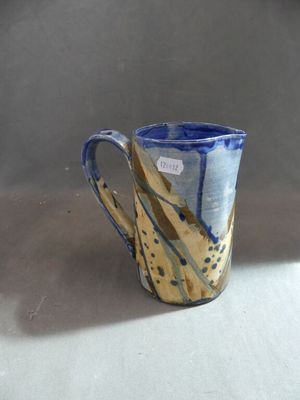 a blue and yellow coffee cup sitting on a table