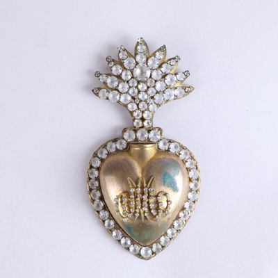 une image représentant une broche en forme de cœur surmontée d'une couronne