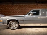 a silver car parked in a garage with a brick wall in the background