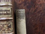two old books sitting on a table next to each other