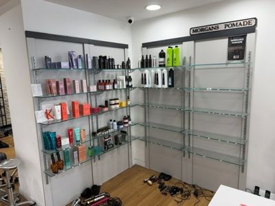 un salon de coiffure dont les étagères regorgent de produits capillaires