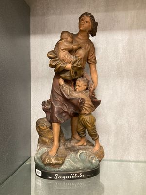 une statue représentant une femme tenant un enfant sur un rocher