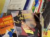 une pile de livres posée par terre, à côté d'une pile de livres pour enfants