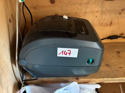 une imprimante posée sur une étagère à côté d'un sac