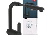 un gros plan sur un robinet noir avec une boîte en arrière-plan