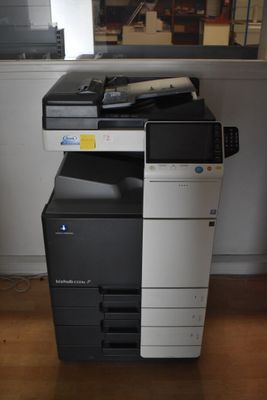 a black and white printer sitting on top of a wooden floor