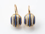 une photo d'une paire de boucles d'oreilles rayées bleues et blanches