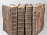 trois vieux livres empilés les uns sur les autres sur une table