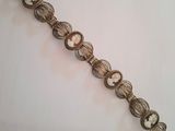 a close up of a metal bracelet with a clock on it