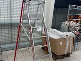 une échelle posée dans une pièce, à côté de quelques cartons