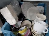 a blue container filled with dishes and cups in a kitchen