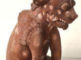 une image représentant une statue en bois d'un chien à la grosse tête