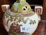 a vase that has a bird on top of it