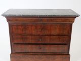 an old wooden chest of drawers with a marble top