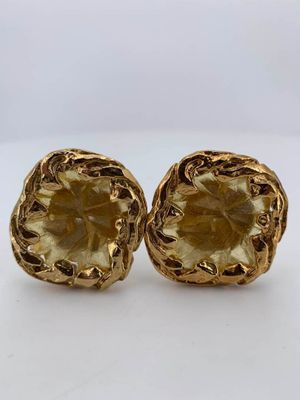 a pair of gold toned earrings with a flower design