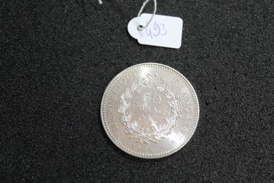 a silver coin on a black surface with a price tag on it