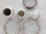 a white table topped with plates and cups and saucers