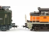 two trains that are sitting side by side on a white surface