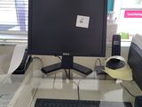 a glass desk with a computer monitor and keyboard on it