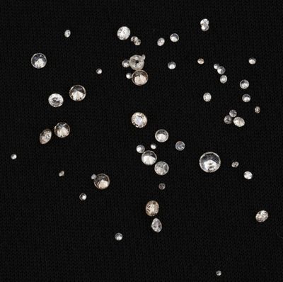 a close up of a bunch of diamonds on a black surface