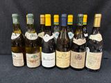 Plusieurs bouteilles de vin sont alignées sur un fond noir