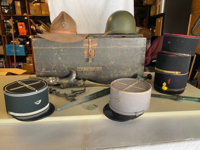 une table sur laquelle se trouvent de nombreux objets, notamment un chapeau, une boîte et une paire de ciseaux