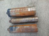 three old metal pipes are sitting on the ground next to each other