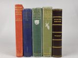 quatre vieux livres sont alignés sur une surface blanche