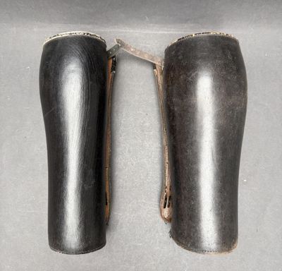 two pairs of black leather shoes are shown on a gray surface