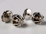 trois paires de boucles d'oreilles à clous en argent posées sur une surface blanche
