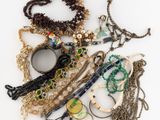 many different types of necklaces and bracelets laid out on a table