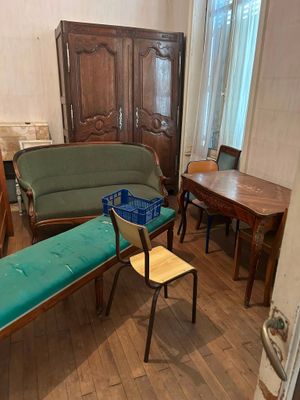 une pièce dans laquelle se trouvent un canapé, un fauteuil, une table et d'autres meubles