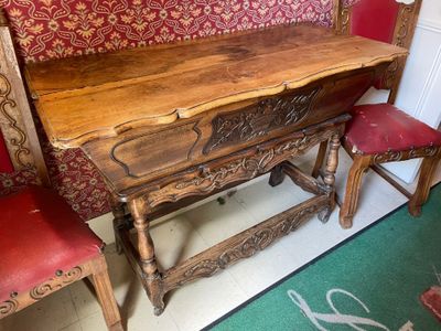 a wooden table and two red chairs in a room