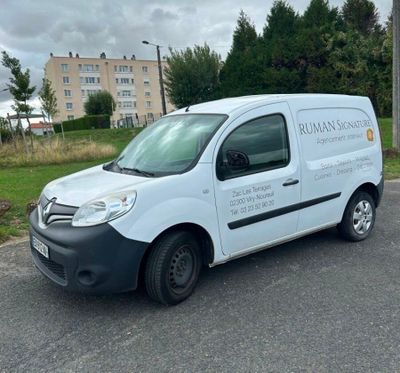 the van is parked on the side of the road in front of a building