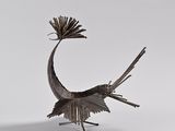 sculpture of a bird made of metal on a white surface