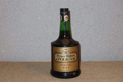 une bouteille d'alcool posée sur une table, avec un mur en arrière-plan