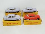 three toy cars are sitting in a box on a white surface