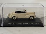 an antique model of a beige car in a clear display case